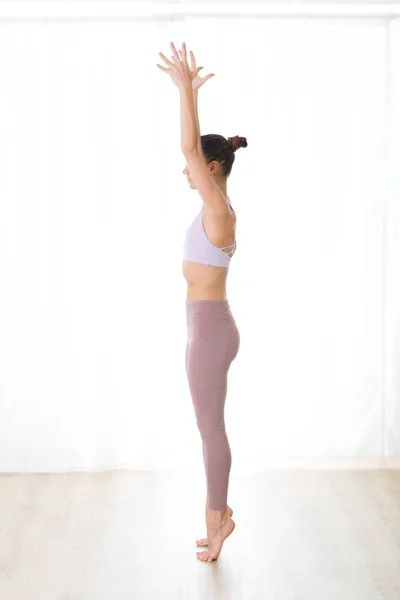 Retrato de una hermosa joven deportista activa practicando yoga en estudio. Hermosa chica práctica Dandayamana Bibhaktapada Paschimotthanasana, de pie pierna separada estiramiento pose —  Fotos de Stock