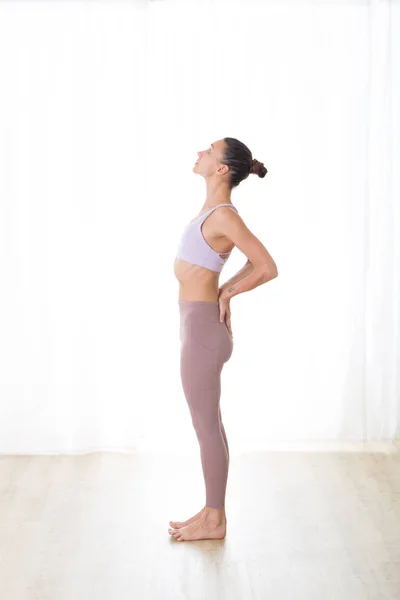 Retrato de una hermosa joven deportista activa practicando yoga en estudio. Hermosa chica practica Ardha Chandrasana, pose de yoga de media luna. Vida activa saludable, ejercicio en el gimnasio — Foto de Stock