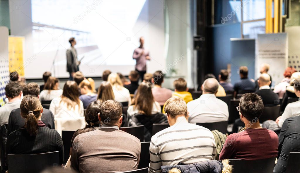 Business speaker giving a talk at business conference event.