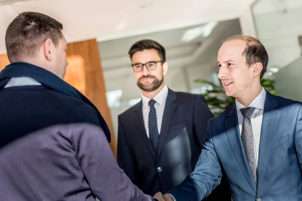 Grupo de gente de negocios confiada saludando con un apretón de manos en la reunión de negocios en la oficina moderna o cerrando el acuerdo estrechando la mano. — Foto de Stock