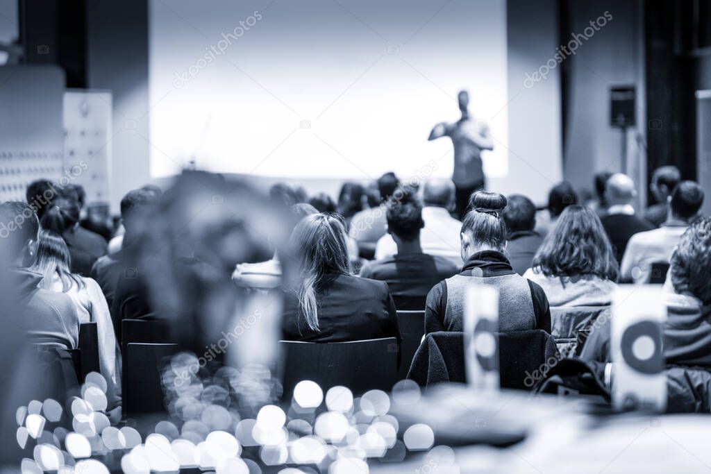 Male public peaker giving presentation on business conference event.