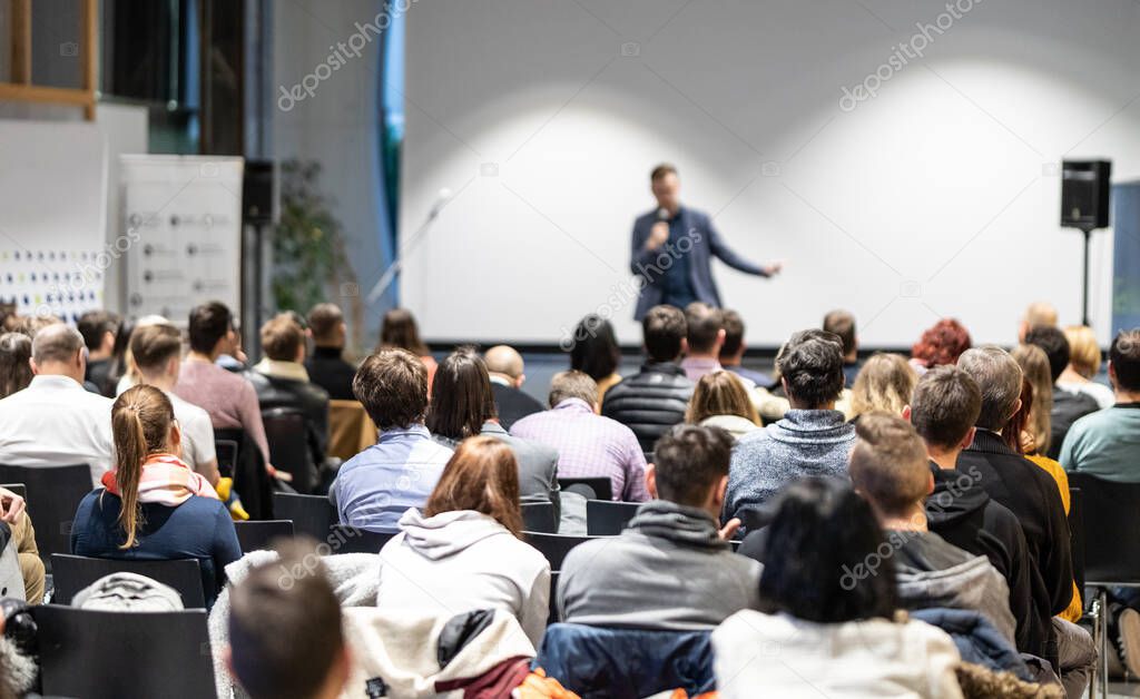 Business speaker giving a talk at business conference event.