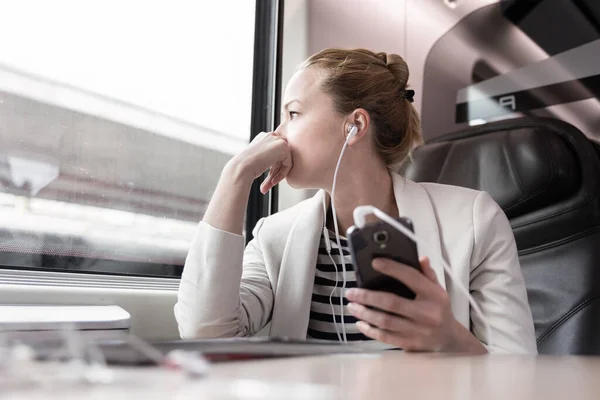 Femme d'affaires communiquant sur un téléphone portable pendant un voyage en train. — Photo