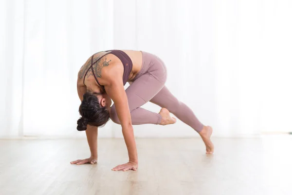 Portret van een prachtige actieve sportieve jonge vrouw die yoga beoefent in de studio. Mooi meisje praktijk Sasangasana, konijn yoga pose. Gezonde actieve levensstijl, sporten in de fitnessruimte — Stockfoto