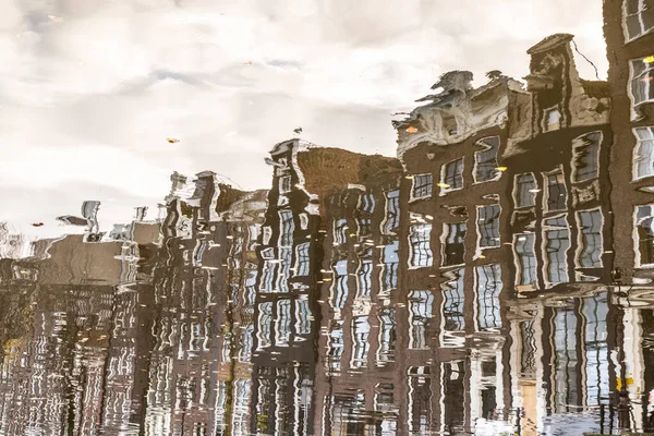 Vacker lugn scen i staden Amsterdam i skymningen. Vattenreflektioner av traditionella hus vid gatukanalen. — Stockfoto