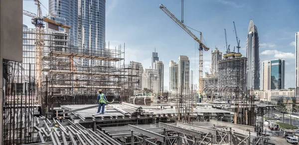 Los trabajadores que trabajan en el sitio de restricción moderna trabaja en Dubai. Consepto de desarrollo urbano rápido —  Fotos de Stock