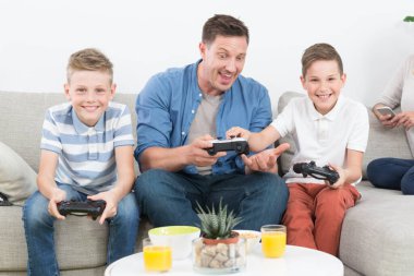 Mutlu genç aile Tv'de video oyunu oynuyor.
