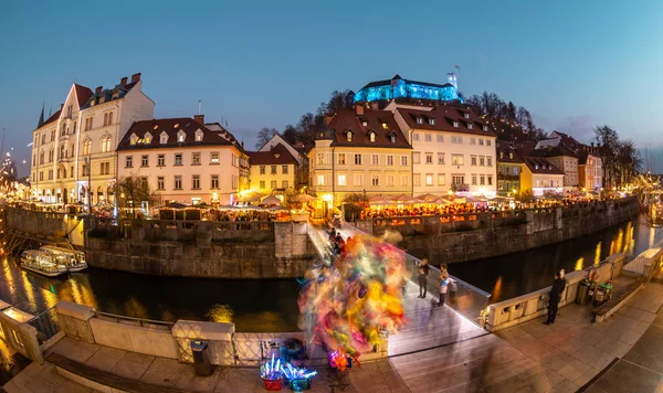 View of lively river Ljubljanica bank in old city center decorated with Christmas lights at dusk. Old medieval Ljubljana cstle on the hill obove the city. Ljubljana, Slovenia, Europe — Stock Photo, Image