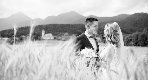 Novio abrazos novia tiernamente en campo de trigo en algún lugar en el campo esloveno . —  Fotos de Stock