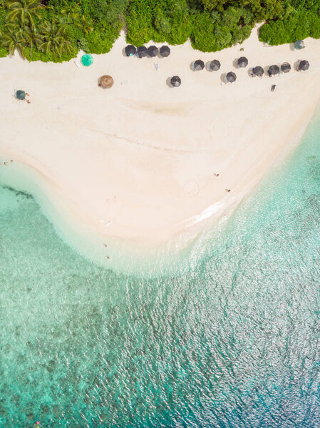 Aerial drone view of picture perfect beach and turquoise lagoon on small tropical island on Maldives