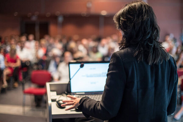 Public speaker giving talk at Business Event.