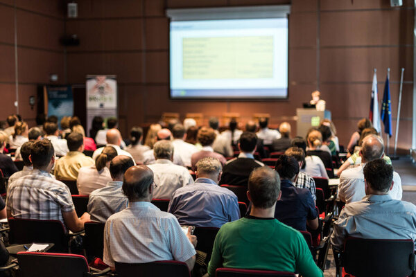 Woman giving presentation in lecture hall at university.