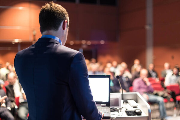 Public speaker giving talk at business event.