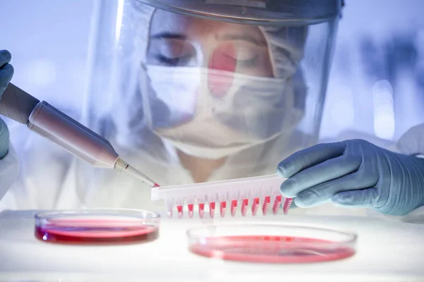 Vrouwelijke wetenschapper werkzaam in het corona virus vaccin ontwikkeling laboratorium onderzoek met een hoogste graad van bescherming vistuig. — Stockfoto
