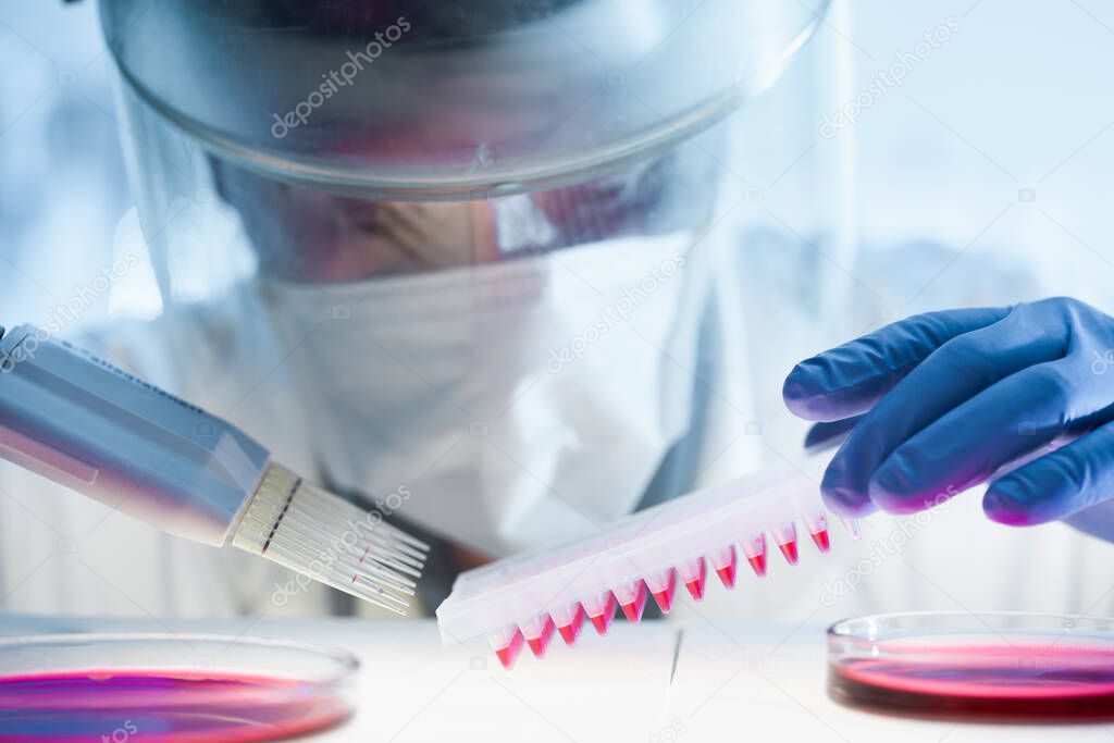 Scientist working in the corona virus vaccine development laboratory research with a highest degree of protection gear.