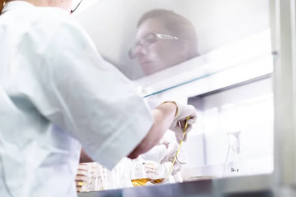 Female scientist working with laminar flow at corona virus vaccine development laboratory research facility. — Stock Photo, Image