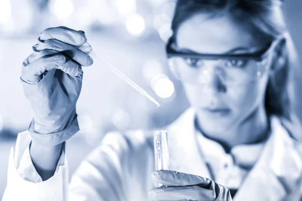 Young scientist pipetting in life science laboratory. — Stock Photo, Image