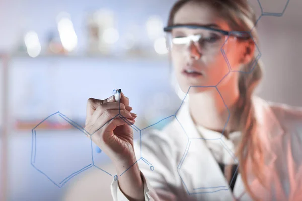 Portret pewnej siebie badaczki w laboratorium life science piszącej strukturalną formułę chemiczną na szklanej tablicy. — Zdjęcie stockowe