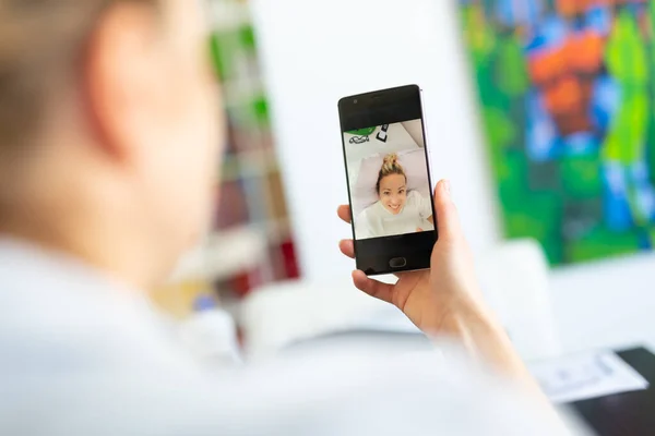 Kvinna hemma använder sociala medier på telefon för videochattar med sina nära och kära under koronaviruspandemin. Stanna hemma, social distanserande livsstil. — Stockfoto