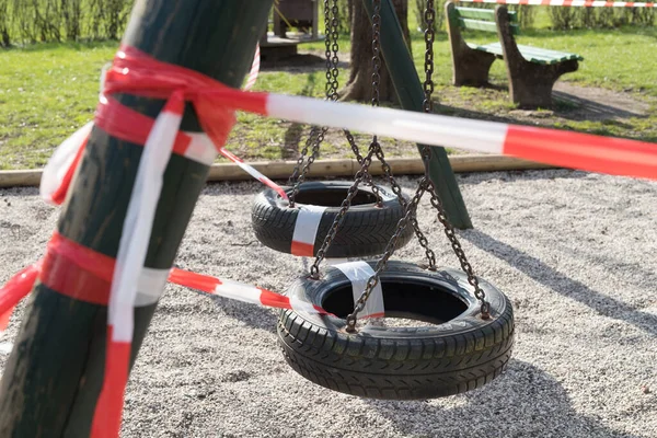 Restricción del virus Corona COVID-19. No hay gente por cuarentena. Parque urbano cerrado. Parque vacío y parque infantil. Quédate en casa compaign. Cinta de advertencia roja en rampas y toboganes. Distanciamiento social — Foto de Stock