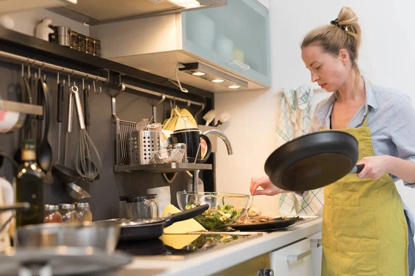Rester à la maison femme au foyer cuisine dans la cuisine, saler le plat dans une casserole, préparer la nourriture pour le dîner de famille . — Photo