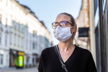 COVID-19 pandemik koronavirüs. 2020 'de Coronavirus hastalığının yayılması için maske takan genç bir kız. SARS-CoV-2 'ye karşı yüzünde tıbbi maske olan genç bayana yakın durun.