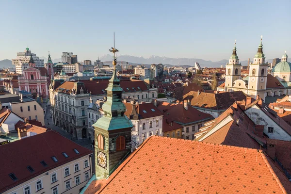 Slovenya 'nın başkenti Ljubljana' daki ortaçağ şehir merkezi, belediye binası ve katedral kilisesinin çatılarının manzara panoramik hava aracı görüntüsü gün batımında — Stok fotoğraf