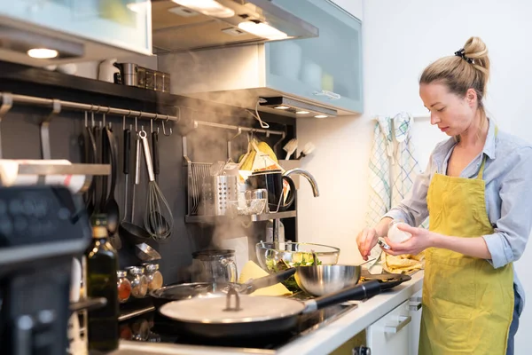 Maradj otthon, háziasszony főz a konyhában, sós tál egy csészealjban, ételt készít a családi vacsorára. — Stock Fotó