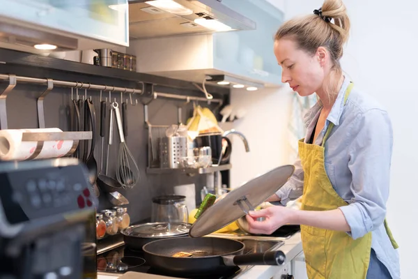 Quédese en casa ama de casa mujer cocina en la cocina, revuelva el plato de freír en una cacerola, preparando la comida para la cena familiar . —  Fotos de Stock