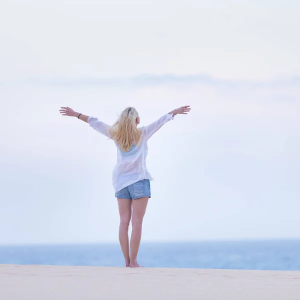 Вільна жінка насолоджується свободою на пляжі вранці . — стокове фото