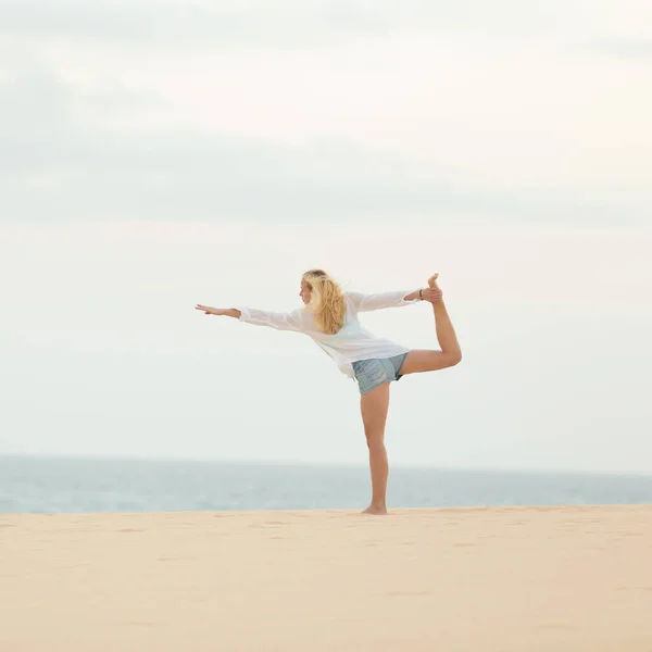Расслабленная женщина наслаждается покоем и свободой во время утренней прогулки в отпуске, пылая в йоге, как поза на пляже — стоковое фото
