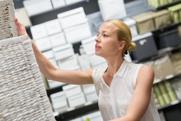 Mujer eligiendo el artículo adecuado para su apartamento en una moderna tienda de muebles para el hogar. —  Fotos de Stock