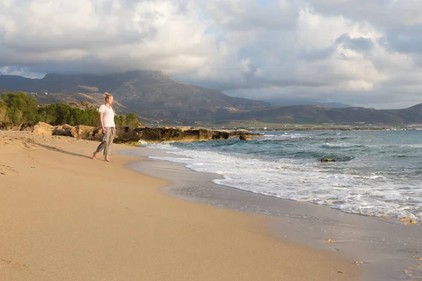 Donna che cammina sulla spiaggia di sabbia all'ora d'oro — Foto Stock
