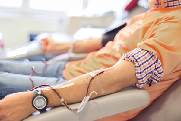 Donante de sangre en donación con una bola hinchable sosteniendo en la mano —  Fotos de Stock