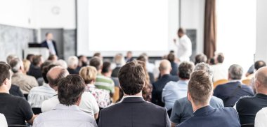 Benim bir sorum var. Bir grup iş adamı konferans salonunda oturuyor. İş adamı kolunu kaldırıyor. Konferans ve Sunum. İş ve Girişimcilik