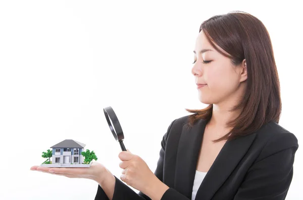 Carrera mujer inspeccionando una casa con lupa —  Fotos de Stock