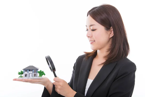 Mulher de carreira inspecionando uma casa com lupa — Fotografia de Stock