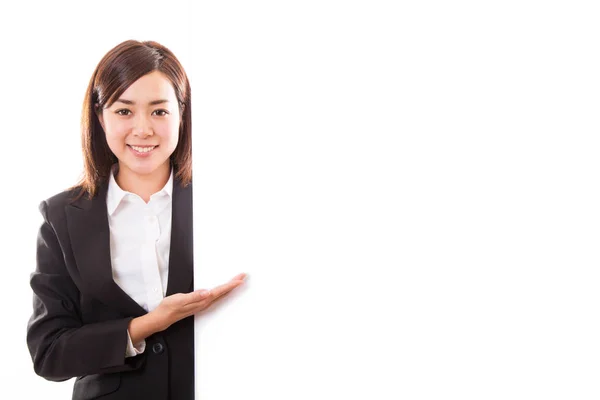 Lächelnde junge Geschäftsfrau zeigt leeres Brett, während — Stockfoto