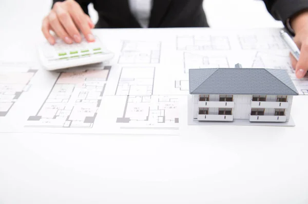 Discussione con agente immobiliare dietro modello di casa — Foto Stock