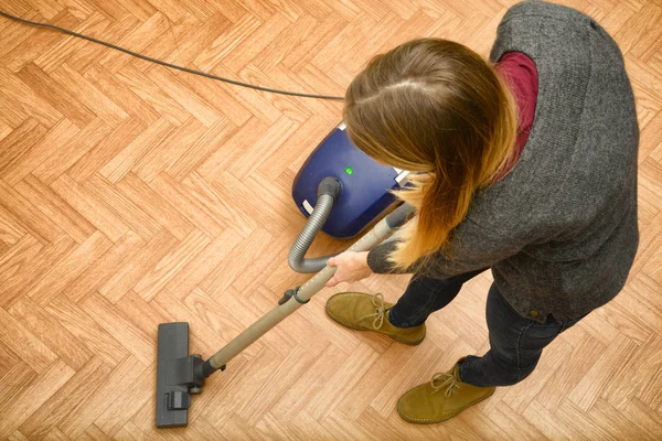 Woman cleaning parquet floor