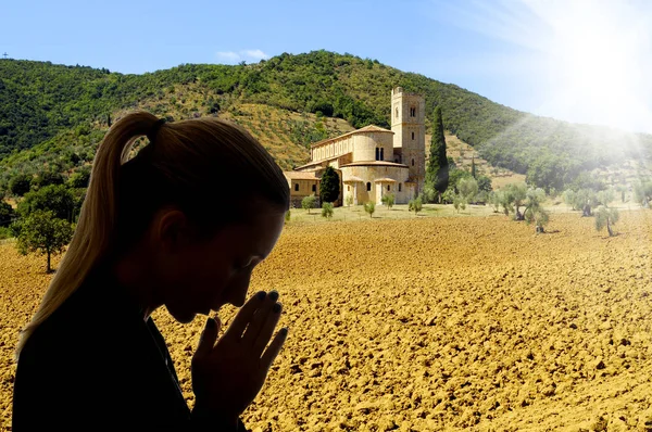 Woman praying in front of a church