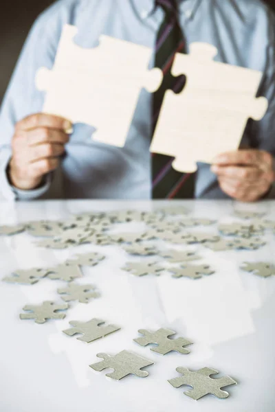 Business man connecting puzzle pieces