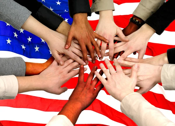 Multiracial stack of hands Over American flag