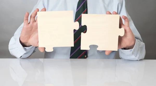 Business man connecting puzzle pieces