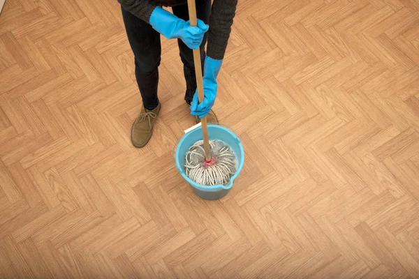 Woman cleaning parquet floor