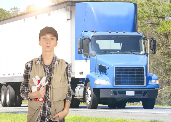 Young woman truck driver in front of truck