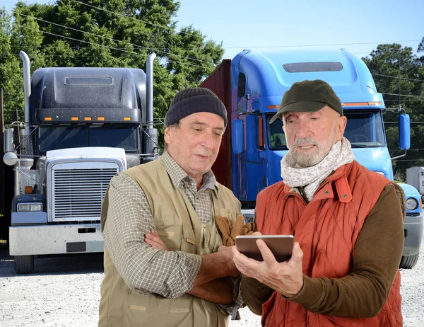 Mature and senior truck drivers with digital tablet