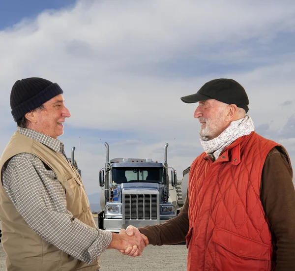 Mature and senior truck drivers handshaking for truck transportation