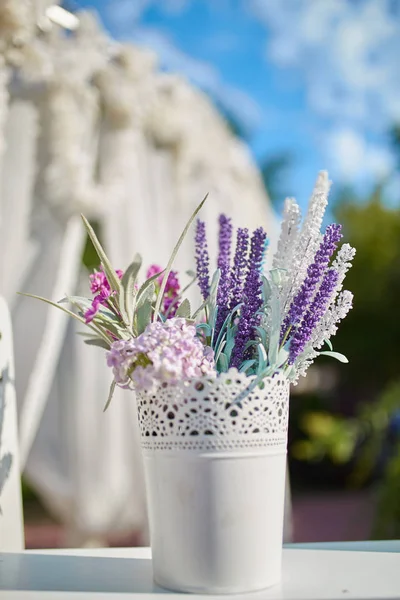 Jar with flowers hanging from chair for wedding