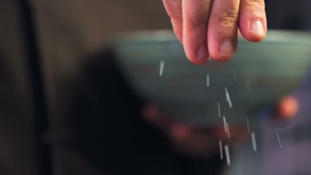 Chef ajoute du sel à la vaisselle. Ajouter du sel avec la main à la vaisselle. Gros plan Nourriture. Processus de cuisson. Chef Plat de Cuisine. Chef préparant la nourriture. (Dragon rouge, ralenti, qualité cinématographique Macro Footage).. Ajout 